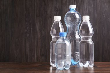 Ahşap masada farklı boyutlarda su şişeleri, metin için yer