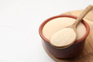 Kasede kuru maya, beyaz masada kaşık, yakın plan. Metin için boşluk