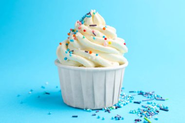 Açık mavi arka planda serpiştirilmiş lezzetli kek, yakın plan.