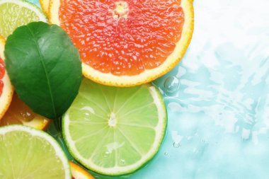 Turkuaz arka planda turkuaz meyveler ve yeşil yaprak dilimleri. Metin için boşluk