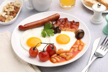 Geleneksel İngiliz kahvaltısı açık gri masada servis edilir, yakın plan.