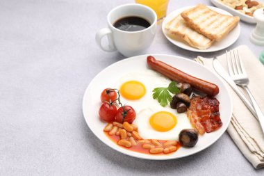 Geleneksel İngiliz kahvaltısı açık gri masada servis edilir, yakın plan. Metin için boşluk