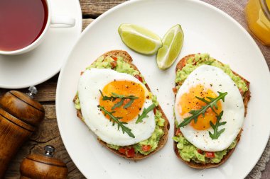 Tahta masada servis edilen avokado tostlu sağlıklı bir kahvaltı.