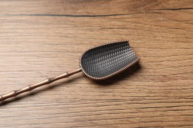 Tahta masada bronz kepçe, yakın plan. Mutfak aletleri