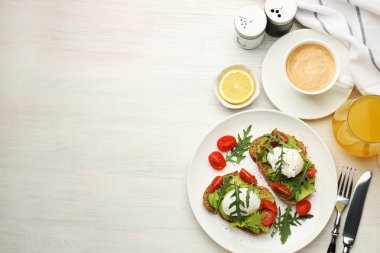 Avokado tostları ve hafif ahşap masada servis edilen haşlanmış yumurtalarla nefis bir kahvaltı. Metin için boşluk
