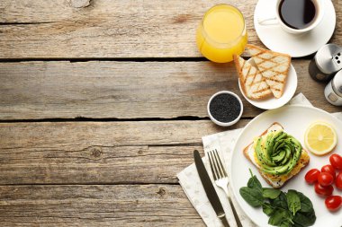 Tahta masada servis edilen avokado tostlu lezzetli bir kahvaltı. Metin için boşluk