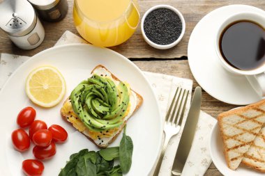 Tahta masada servis edilen avokado tostuyla nefis bir kahvaltı.
