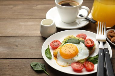 Avokado tostlu sağlıklı kahvaltı ahşap masada servis edilir, yakın plan. Metin için boşluk