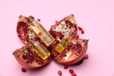 Pembe arka planda gerekli yağ, nar ve tohumlar, yakın plan.