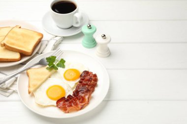 Beyaz ahşap masada servis edilen omlet ve pastırmayla nefis bir kahvaltı. Metin için boşluk