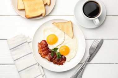 Beyaz ahşap masada servis edilen omlet ve pastırmayla nefis bir kahvaltı.