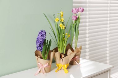 Bir çok güzel bahar çiçekleri kaplarda beyaz şifoniyerlerde