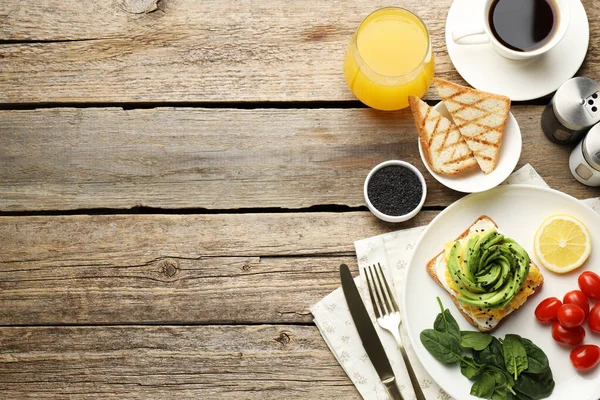 Tahta masada servis edilen avokado tostlu lezzetli bir kahvaltı. Metin için boşluk