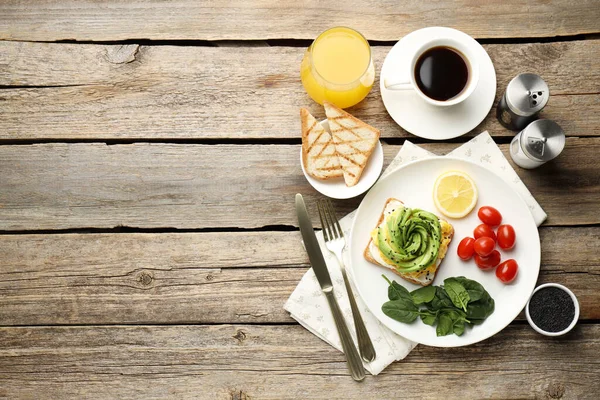 Tahta masada servis edilen avokado tostlu lezzetli bir kahvaltı. Metin için boşluk