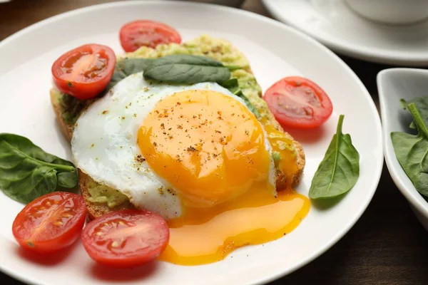Tahta masada servis edilen avokado tostlu sağlıklı bir kahvaltı.