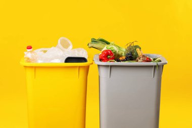 Çöp tenekeleri turuncu arka planda, yakın plan. Atık sıralama