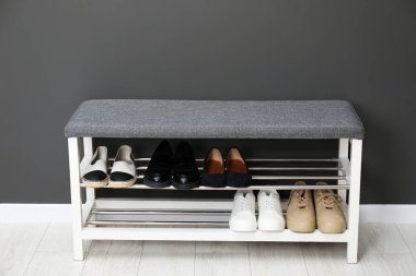 Gri duvarın yanında farklı ayakkabıları olan ayakkabı deposu.