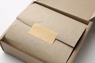 Beyaz arkaplanda ambalajlı ve boş etiketli karton kutu, kapat