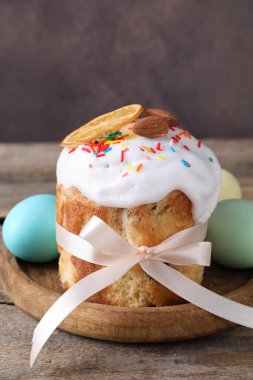 Delicious Easter cake and painted eggs on wooden table, closeup
