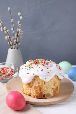 Lezzetli Paskalya pastası, boyanmış yumurtalar ve söğüt dalları beyaz ahşap masada, yakın plan.