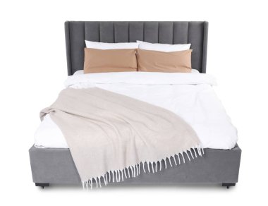 Büyük yatak bej battaniyeli ve beyaz yastıklı.