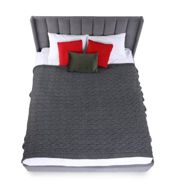 Gri battaniyeli ve beyaz yastıklı büyük bir yatak.