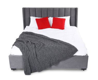Gri battaniyeli büyük yatak ve beyaz yastıklı kırmızı yastıklar.