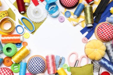 Beyaz arka planda, düz zeminde dikiş malzemeleri çerçevesi. Metin için boşluk