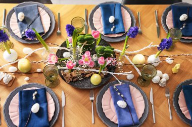 Paskalya kutlaması. Çiçekli şenlik masası ve kapalı alanda yumurtalar, düzlük.