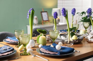 Paskalya kutlaması. Çiçeklerle süslü masa ve kapalı alanda yumurtalar.