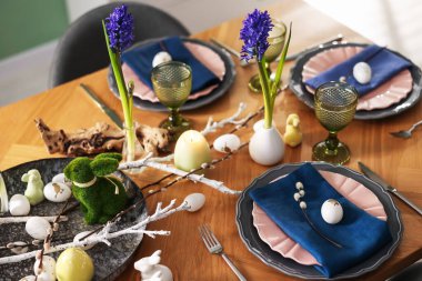 Paskalya kutlaması. Çiçeklerle süslü masa ve kapalı alanda yumurtalar.