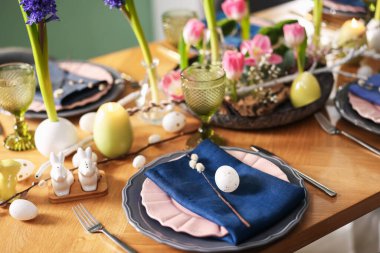 Paskalya kutlaması. Çiçekli şenlik masası ve kapalı mekanda yumurtalar, yakın plan.