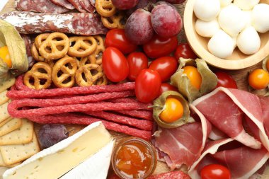 Arka planda lezzetli mezeler olan şarküteri tahtası, üst görünüm