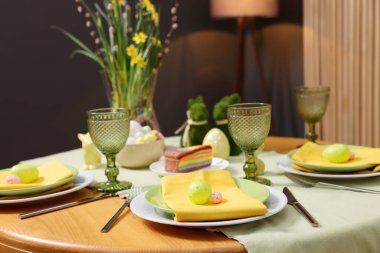 Paskalya kutlaması. Zarif bulaşık takımları ve boyalı yumurtalarla şenlik masası, yakın plan.