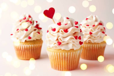 Sevgililer günün kutlu olsun. Kremalı ve kırmızı kalp şeklinde şekerlemeli kapkekler.