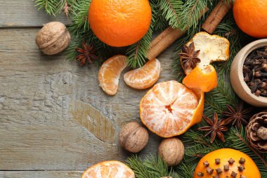 Olgun mandalinalar, baharatlar, cevizler, köknar ağacı dalları ve ahşap masa üzerinde koni, düzlük. Metin için boşluk