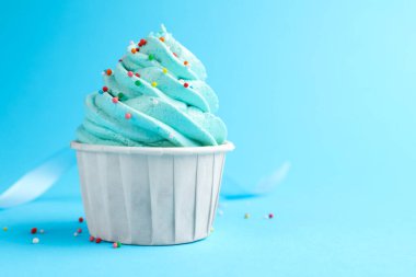 Açık mavi arka planda serpiştirilmiş lezzetli kek, yakın plan. Metin için boşluk