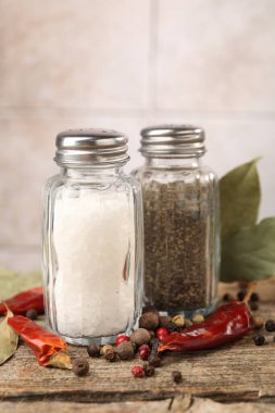 Ahşap masada baharatlı tuzluklar ve biberlikler bulanık arka planda, yakın plan