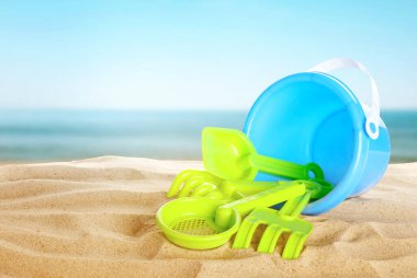 Deniz kenarındaki kumda parlak plastik plaj oyuncakları. Yaz zamanı.