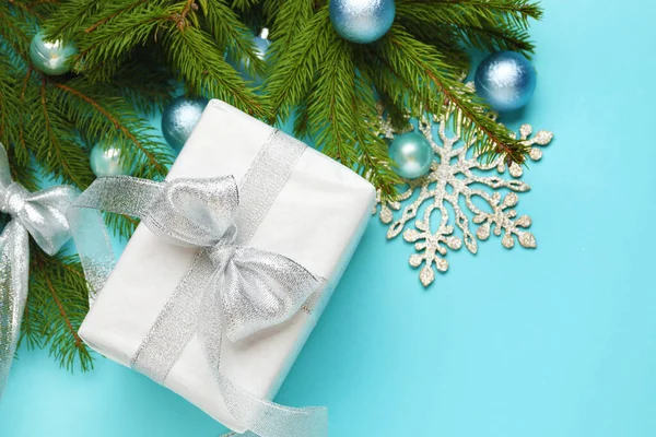 Hediye kutusu ve açık mavi arkaplanlı dekorlu Noel kompozisyonu. Metin için boşluk