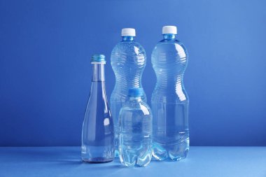 Mavi arka planda farklı boyutlarda su şişeleri