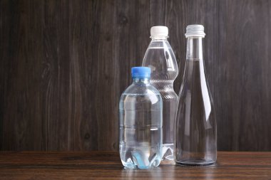 Ahşap masada farklı boyutlarda su şişeleri, metin için yer