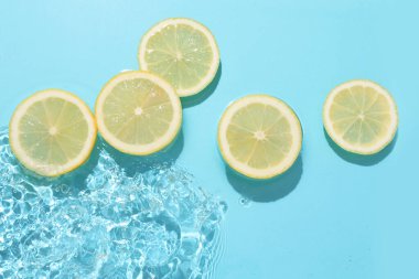 Açık mavi zemin üzerinde limon dilimleri, düz uzanmış.