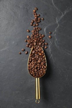 Kahve çekirdekleri siyah masanın üstünde, en üstte.