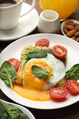 Tahta masada servis edilen avokado tostlu sağlıklı bir kahvaltı.