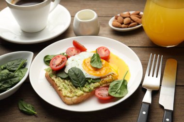 Tahta masada servis edilen avokado tostlu sağlıklı bir kahvaltı.