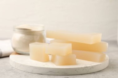 Jelatin tozu ve jöle parçaları gri masada, yakın plan.