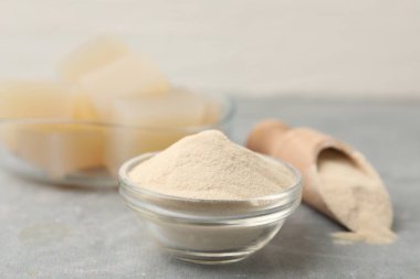 Jelatin tozu ve jöle küpleri gri masada, yakın plan.