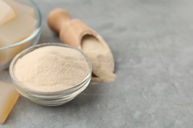 Jelatin tozu ve jöle küpleri gri masada, yakın plan. Metin için boşluk