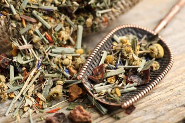 Çuvalda kurutulmuş bitki çayı ve ahşap masada metal spatula, yakın plan.